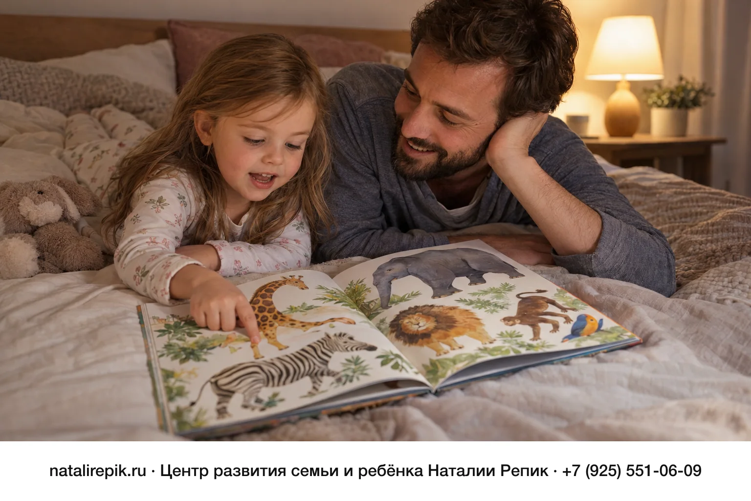Папа и дочка лет четырёх лежат на кровати под мягкой лампой: между ними открыта большая книга с яркими картинками животных, девочка показывает на картинку и рассказывает, папа слушает